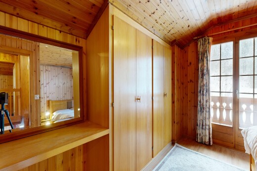chambre avec wood wall, mur en bois, inside property, wood finish floor, et sol en finition bois