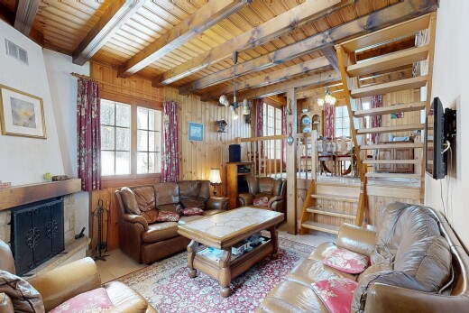 salon avec inside property, mur en bois, wood wall, escaliers, et cheminée
