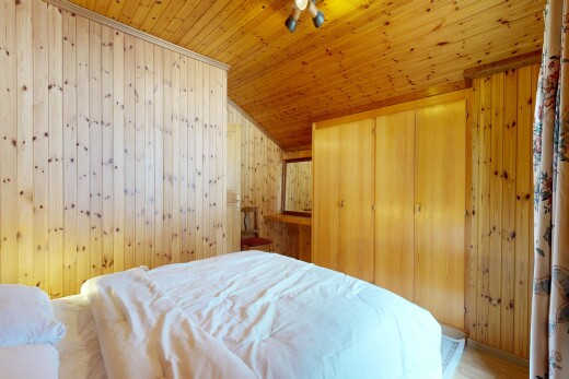 chambre avec wood wall, mur en bois, placard, vaulted ceiling, et plafond voûté