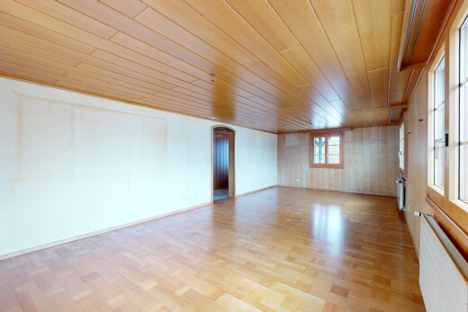 pièce vide avec radiateur, lumière naturelle, et sol en finition bois