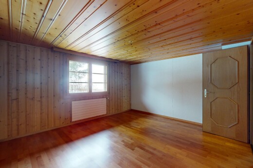pièce vide avec lumière naturelle, radiateur, sol en finition bois, et plafond en bois