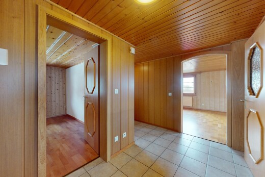 couloir avec lumière naturelle, sol en carrelage, mur en bois, plafond en bois, et passages en arc