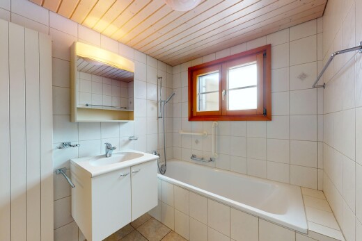 salle de bains avec miroir, évier, lumière naturelle, douche-bain combinés, et mur en carrelage