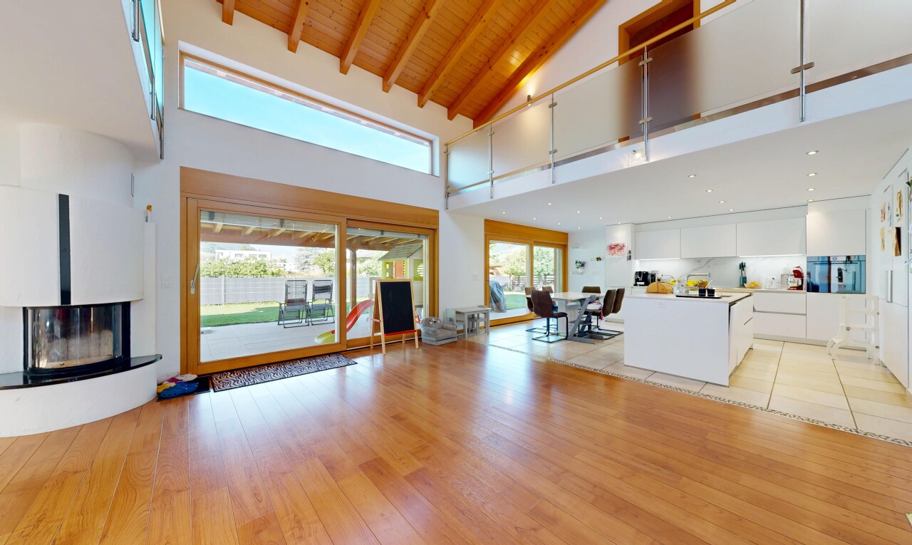 living room featuring a glass covered fireplace, a high wood beamed ceiling, and light wood-style floors