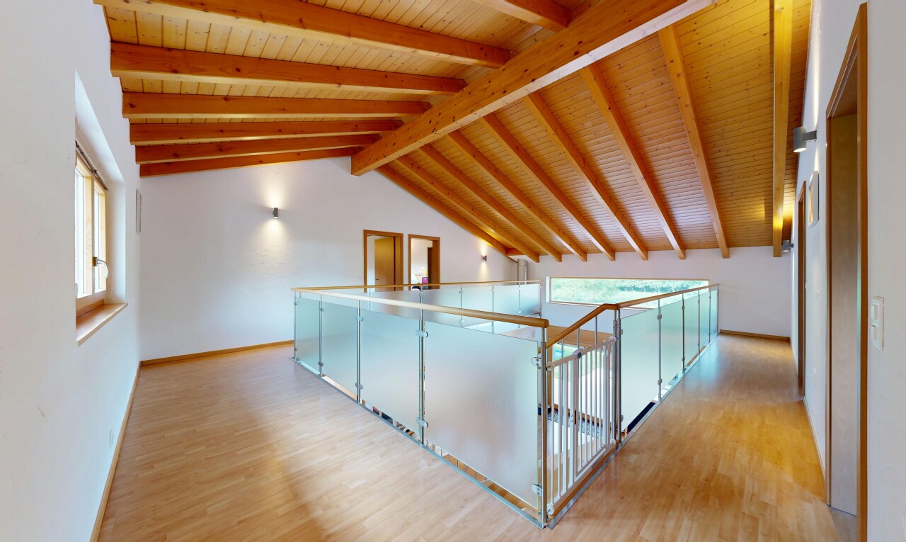 hallway with light wood-style floors and a wood ceiling with exposed beams