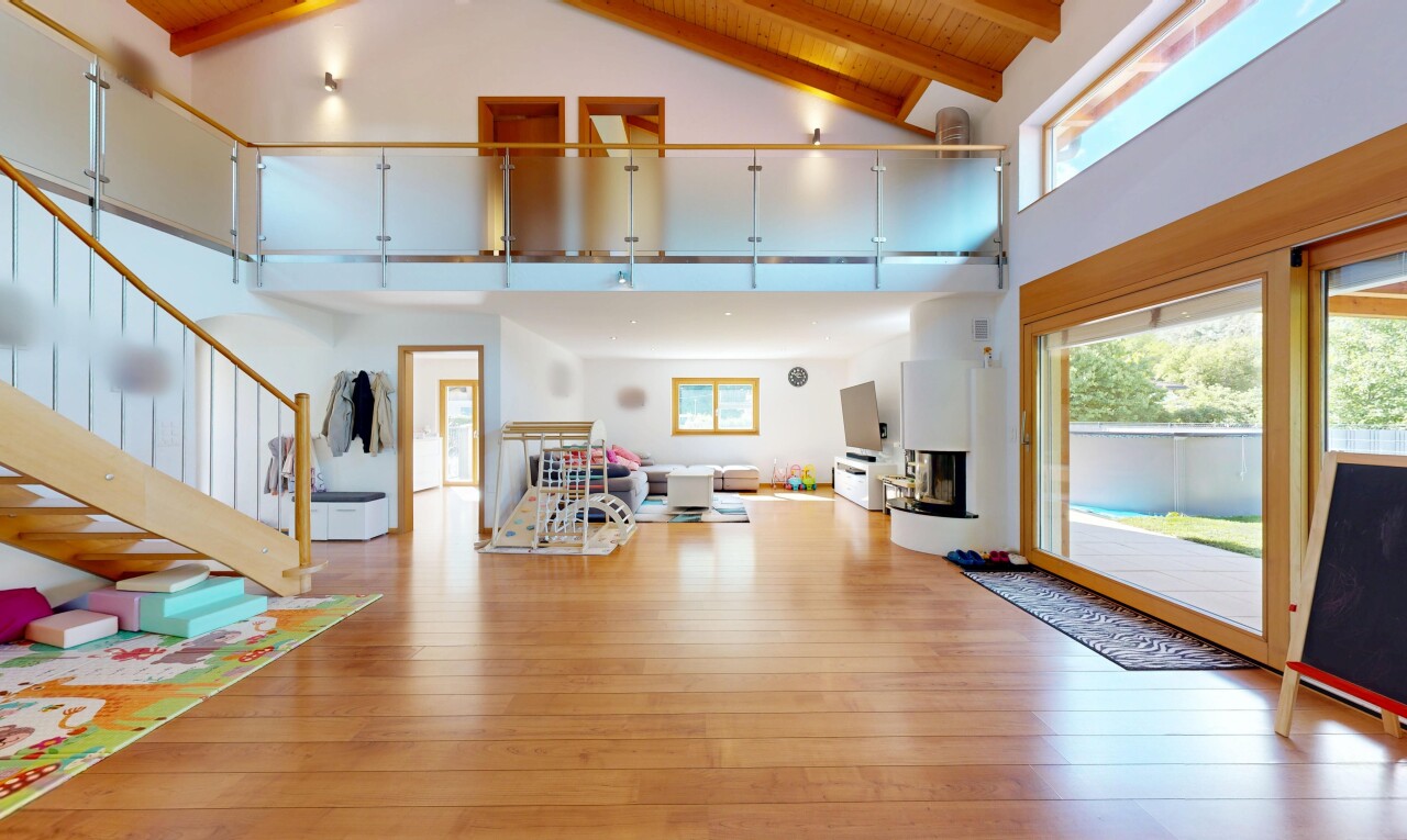 living room featuring light wood-style flooring and a high wooden beamed ceiling