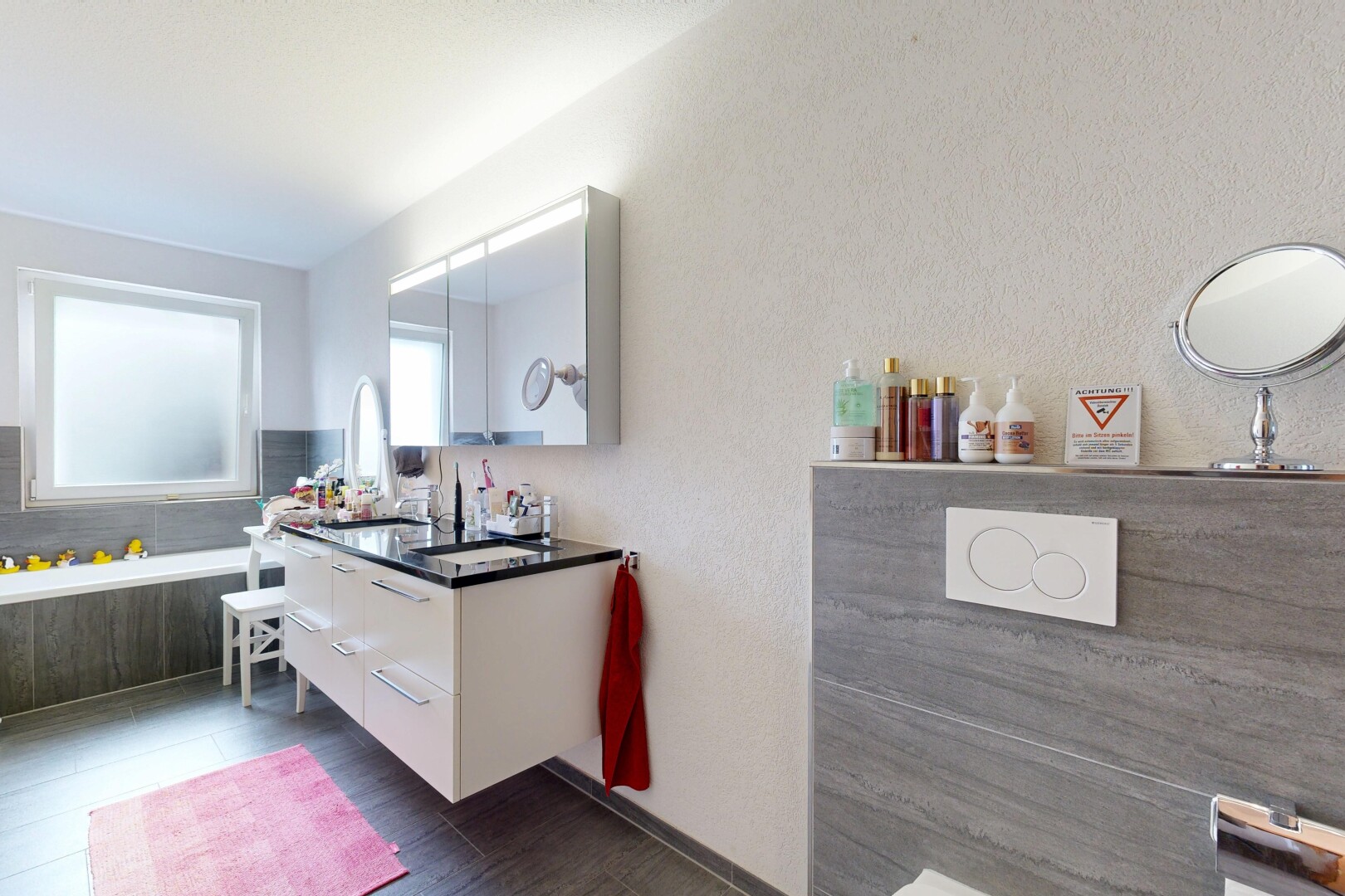 bathroom with a textured wall and vanity