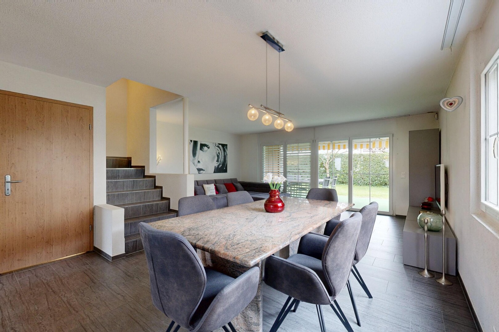 living / dining room featuring dark wood finished floors and stairway