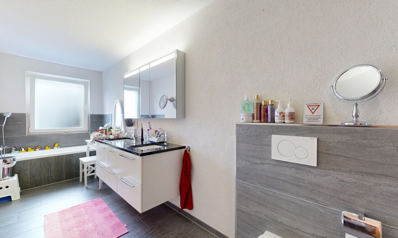 bathroom with a textured wall and vanity