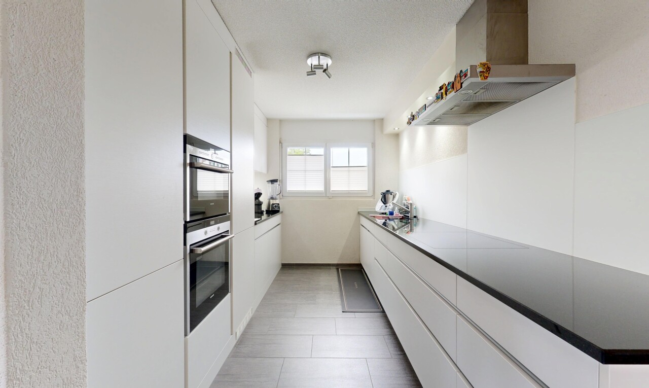 kitchen with white cabinets, wall chimney exhaust hood, double oven, modern cabinets, and light tile patterned floors