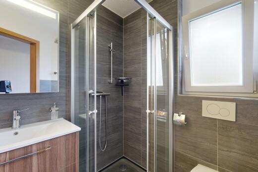 bathroom with vanity, a shower stall, and tile walls