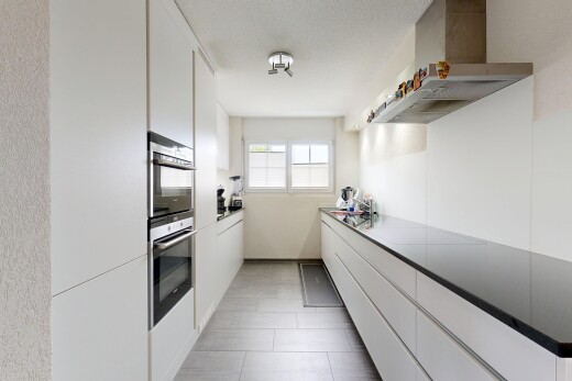 kitchen with white cabinets, wall chimney exhaust hood, double oven, modern cabinets, and light tile patterned floors