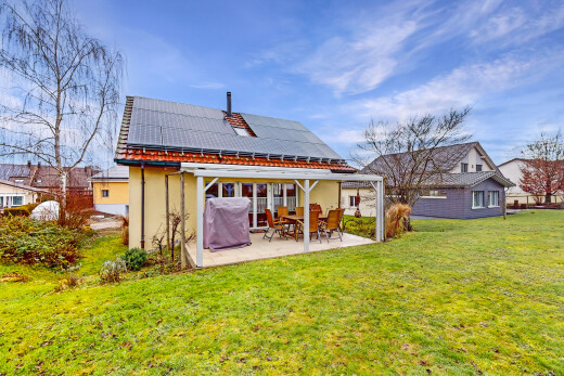 außenansicht mit terrasse, solaranlage, und rasen