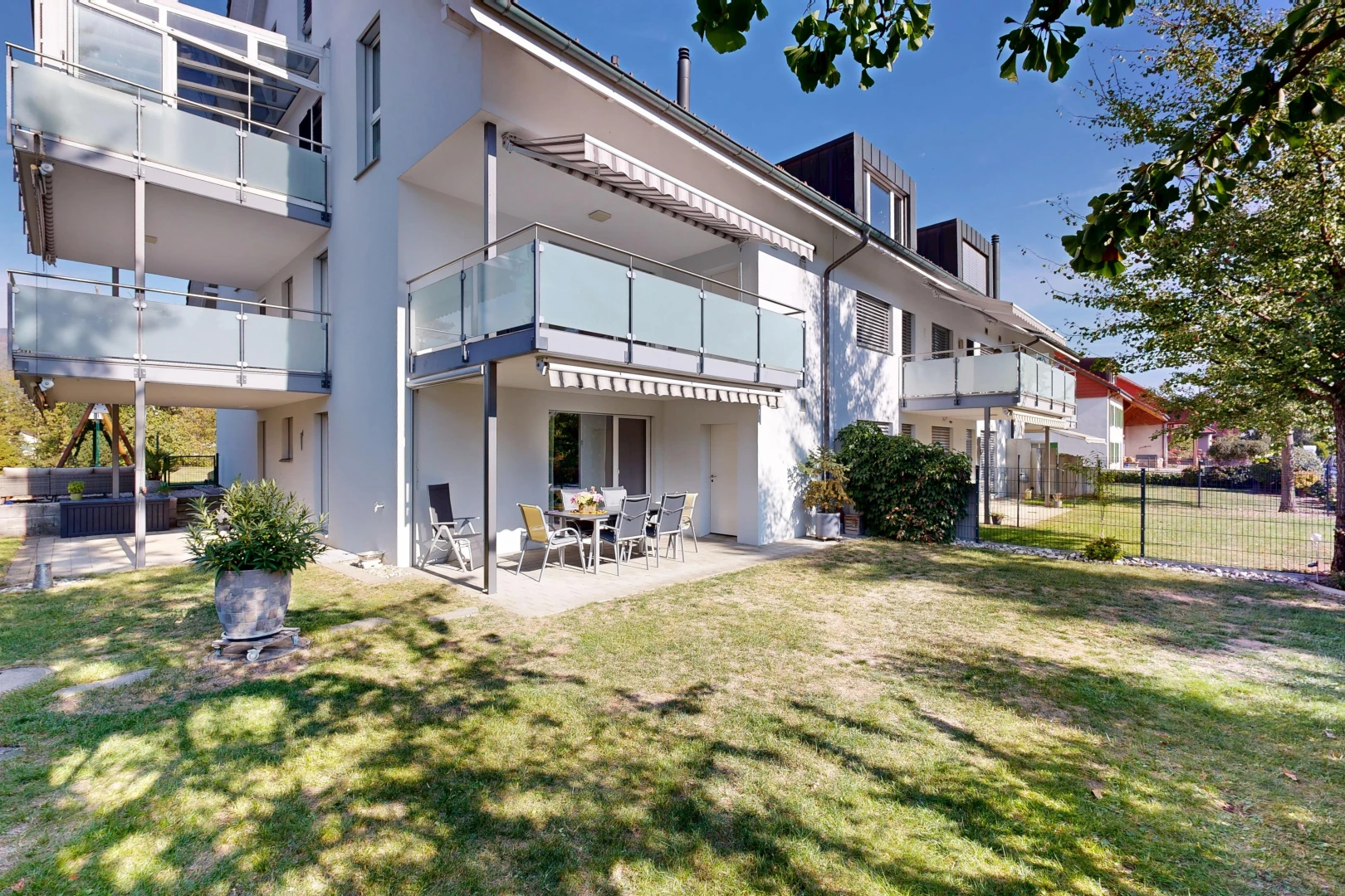 façade avec balcon, pelouse, terrasse, clôture, et day time