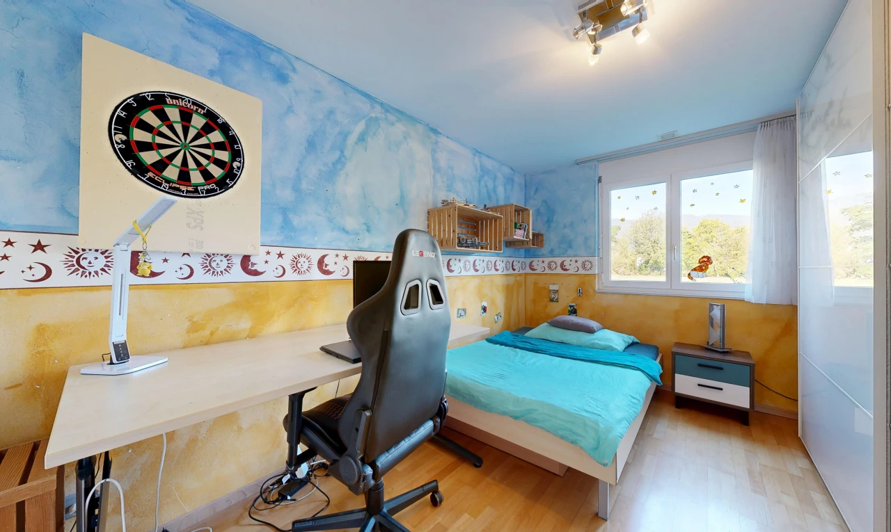 chambre avec wall frieze, éclairage sur rail, sol en finition bois, wood finish floor, et espace bureau