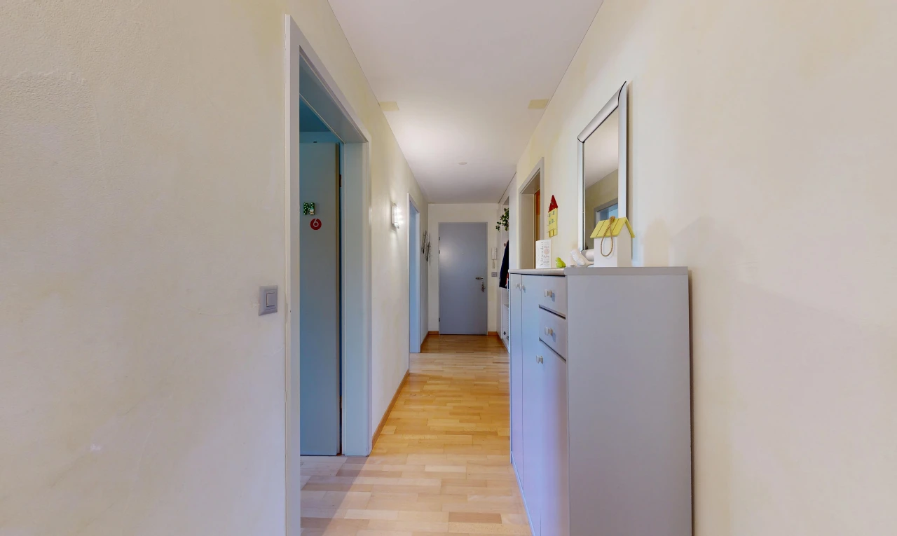 couloir avec light floor, cloison sèche, drywall, sol en finition bois, et wood finish floor
