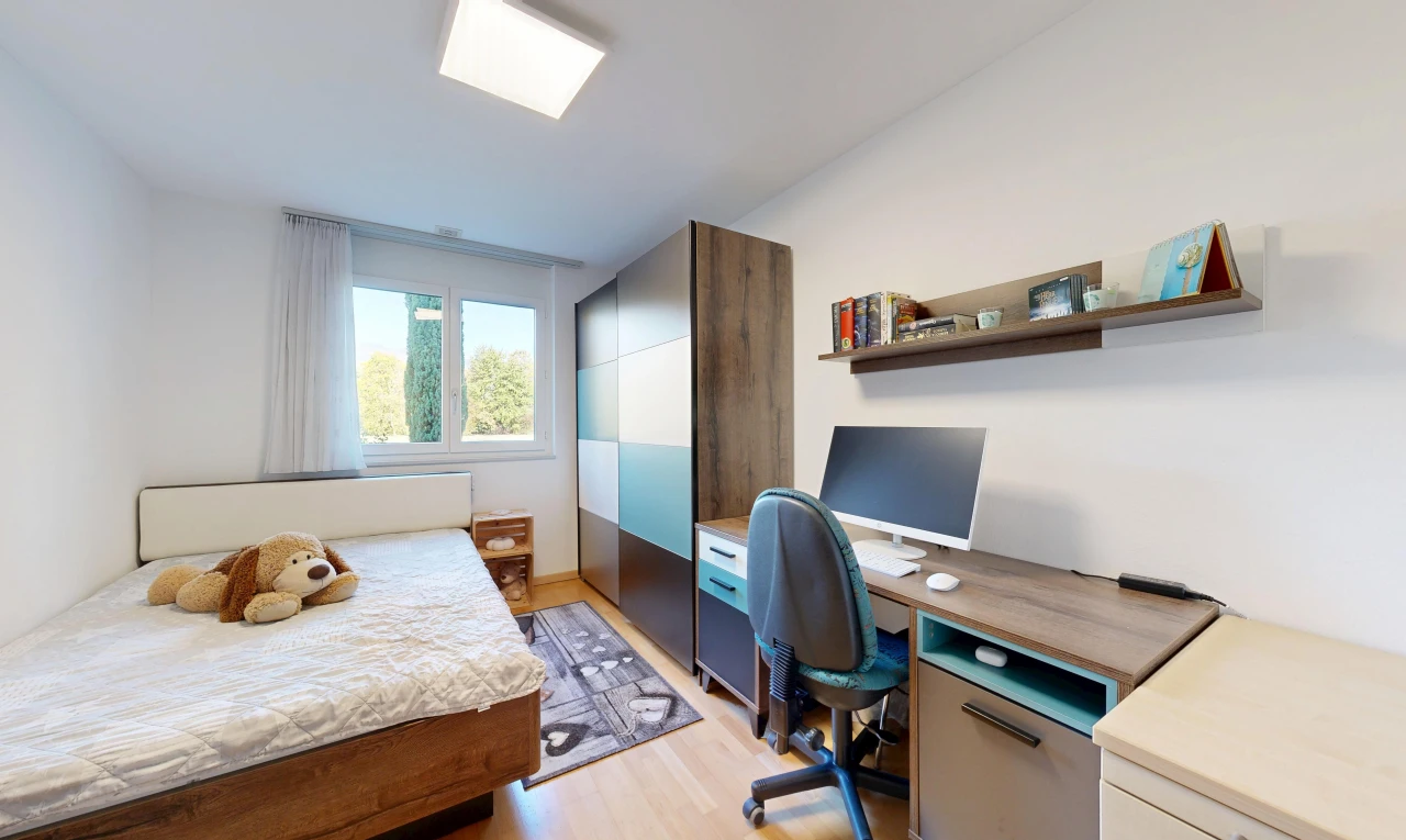 chambre avec télévision, light floor, cloison sèche, drywall, et sol en finition bois