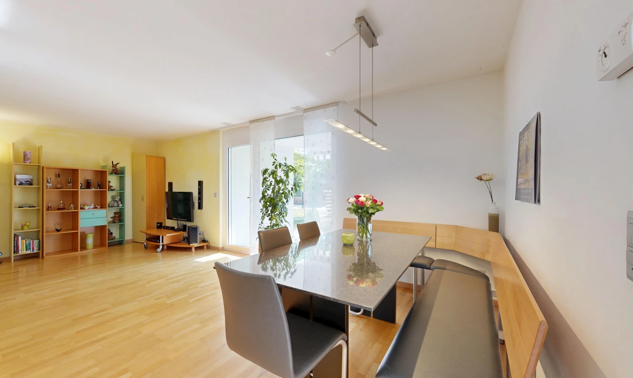salle à manger avec cloison sèche, drywall, télévision, sol en finition bois, et wood finish floor