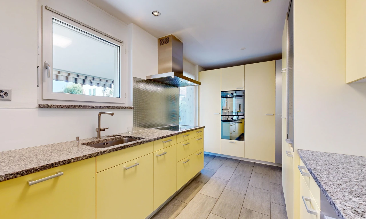 cuisine avec hotte, light floor, plans de travail en pierre, stone countertops, et évier