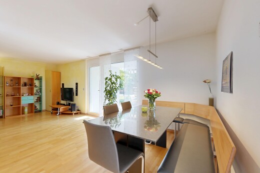 salle à manger avec cloison sèche, drywall, télévision, sol en finition bois, et wood finish floor