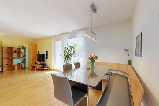 salle à manger avec cloison sèche, drywall, télévision, sol en finition bois, et wood finish floor
