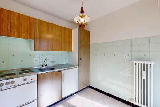 cuisine avec radiateur, light countertops, plans de travail, medium brown cabinets, et armoires marron moyen