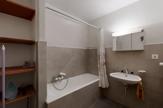 salle de bains avec salle de bain complète, douche-bain combinés, évier, mur en carrelage, et tile wall