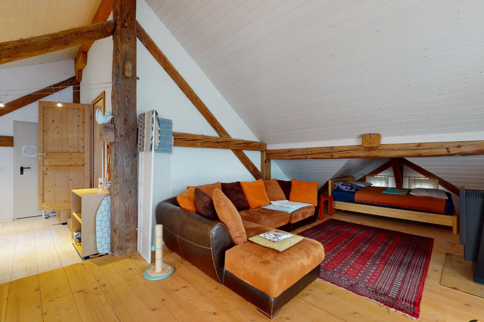 chambre avec poutres apparentes, plancher de bois, et plafond voûté