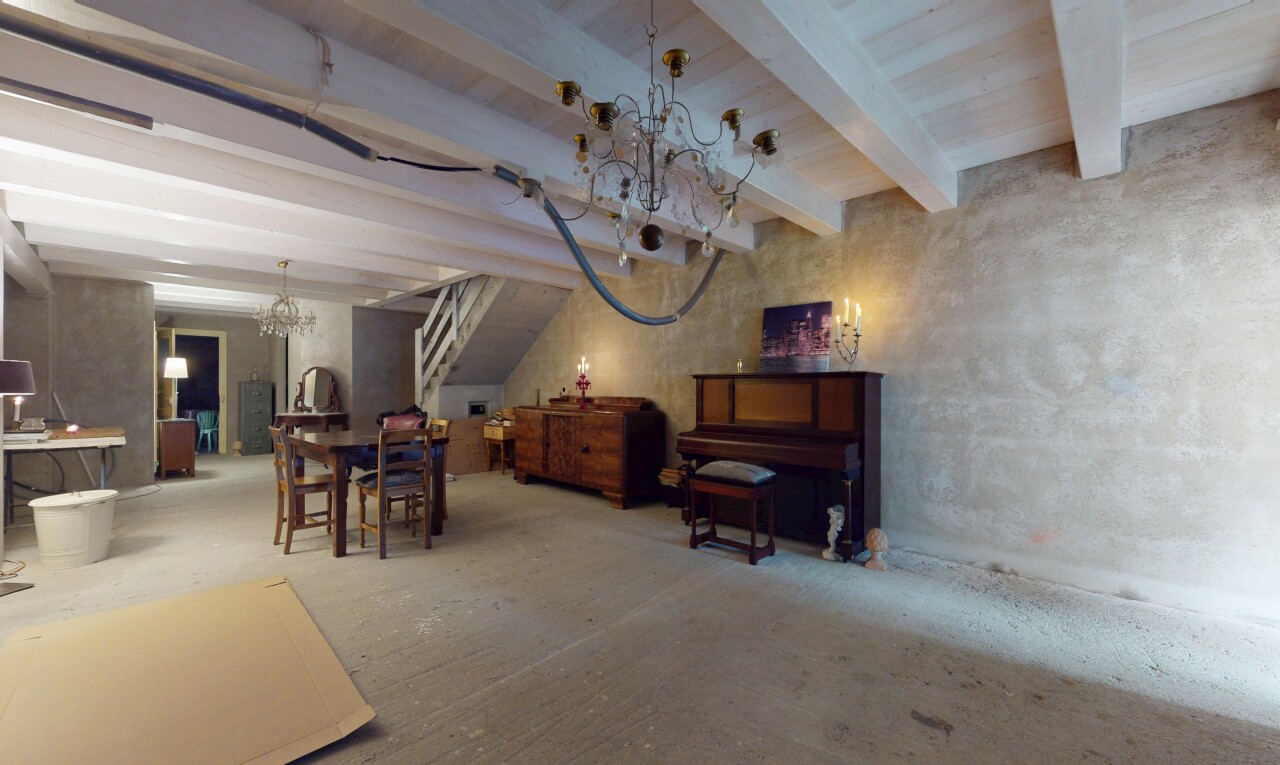 salon / salle à manger avec poutres apparentes et mur en béton