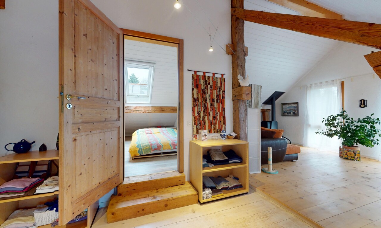 escaliers avec poutres apparentes, lumière naturelle, plancher de bois, et plafond voûté