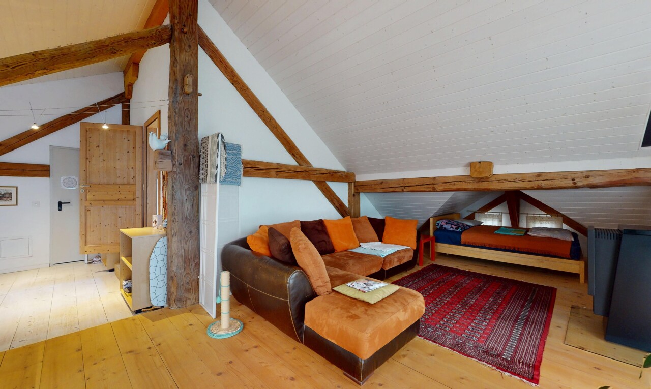 chambre avec poutres apparentes, plancher de bois, et plafond voûté