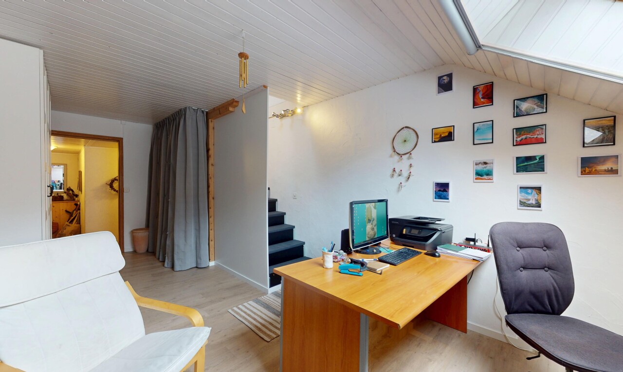 bureau avec plafond voûté, plancher de bois, et télévision