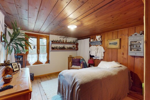 zimmer / schlafzimmer mit holzdecke, holzwand, natürliches licht, parkettboden, und niedrige decke
