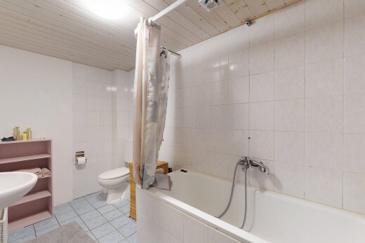 bad mit fliesenboden, fliesenwand, toilette, und kombiniertes bad / dusche