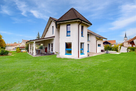 außenansicht mit terrasse, rasen, property visible, stuckverkleidung, und day time