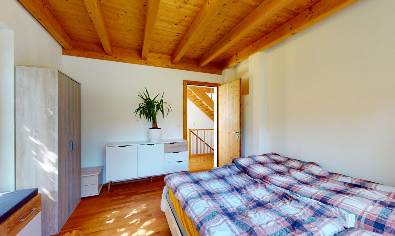 zimmer / schlafzimmer mit balkendecke, beamed ceiling, inside property, holzfußboden, und wood finish floor