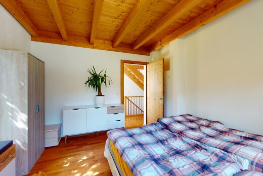 zimmer / schlafzimmer mit balkendecke, beamed ceiling, inside property, holzfußboden, und wood finish floor